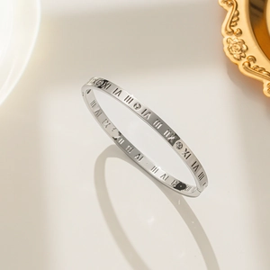 Silver titanium steel bangle with Roman numerals and three diamonds on a grey background