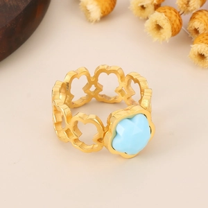 Detailed view of golden ring with hollow petal design and light blue floral center
