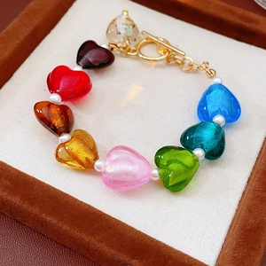 Detail of colorful heart glass beads and pearls bracelet on a brown velvet jewelry tray