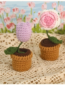 Macro shot of handmade crochet purple tulip and pink rose potted plant with yarn texture