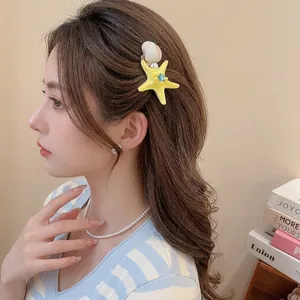 Starfish hair clip with pearls and shells worn by a model for a beach holiday look
