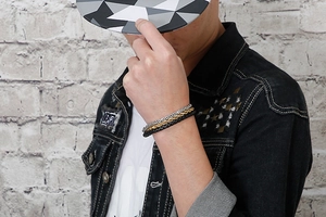 Close-up of triple-layered men's bracelet with chain and braided leather on a wrist