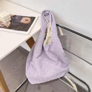 Detail of light purple pleated tote bag with 3D texture on a stylish folding chair