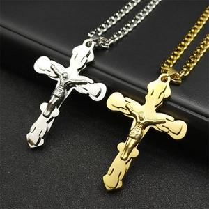 Gros plan de colliers croix celtique en argent et or avec chaînes cubaines sur fond noir