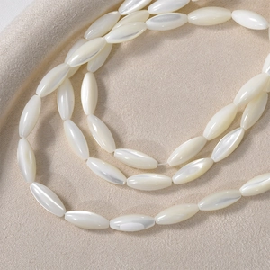 Detailed close-up of natural white trochus shell oval beads with a pearly luster finish