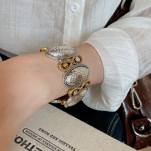 Close-up of vintage mixed metal textured heart bracelet with crystal accents on a wrist