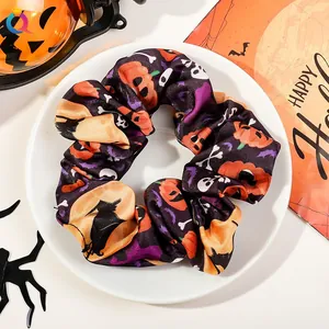 Halloween scrunchie with pumpkin and bat prints on a white plate decorative background