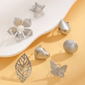 Macro detail of 7-piece silver ear cuff set featuring starfish and floral textures