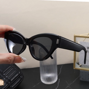 Close-up of black cat-eye sunglasses with thick frames and silver metal temple accents
