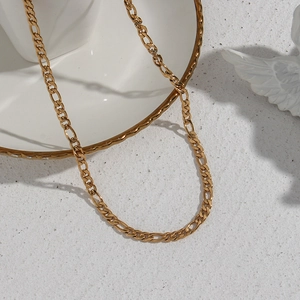 Detail shot of golden Figaro chain showing polished metal texture and links