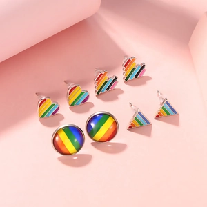 Close-up of rainbow heart and geometric stud earrings with silver-tone metal base