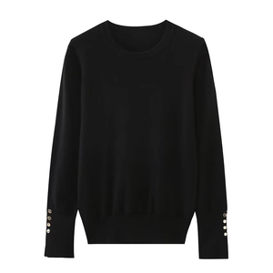 Detailed view of long sleeve knit top with decorative gold buttons on cuffs