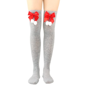 Close-up of gray knitted over-knee socks with red satin bows and white pompoms