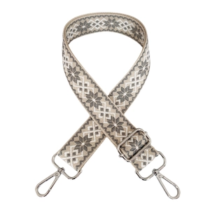 Detail of grey ethnic jacquard bag strap with geometric patterns and silver metal hooks