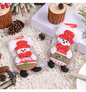 Close-up of plush snowman and bear Christmas stockings with linen texture and bells