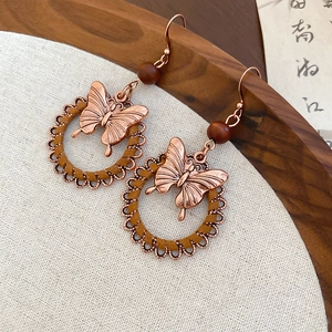 Vintage bronze butterfly drop earrings with wooden beads and woven circular frame design