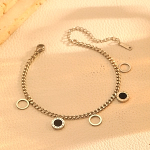 Detailed close-up of a silver Cuban link bracelet with black Roman numeral charms
