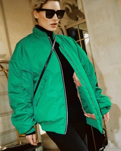 Detail view of bright green oversized bomber jacket with ruched sleeves and loose fit design