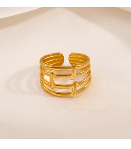 Macro detail of gold plated multi-layer hollow line ring on soft textured fabric