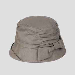 Detalle de un elegante sombrero de lino topo con un lazo y pliegues texturizados