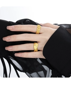 Detailed view of brushed gold rings with zircon inlay on model wearing black mesh