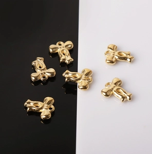 Detailed close-up of six gold metallic bow charms for DIY jewelry making accessories