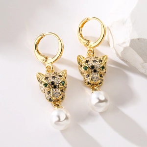 Gold leopard head earrings with green eyes, sparkling crystals, and white pearls on white