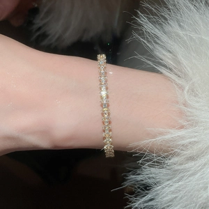 Detailed view of a gold tennis bracelet with brilliant cubic zirconia on a wrist