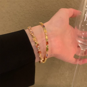 Bracciali geometrici con cristalli colorati placcati in oro indossati da una modella