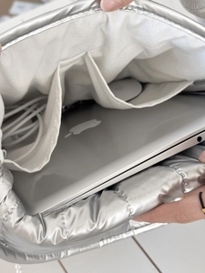 Detailsicht der silbernen gesteppten Laptoptasche mit Innenfächern für Maus und Kabel
