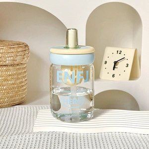 Detail of ENFJ personality glass tumbler with light blue lid and yellow straw