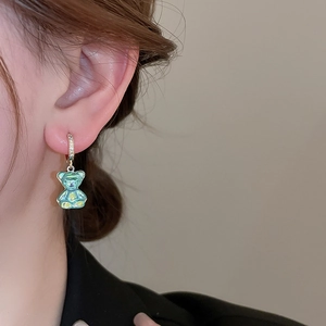 Détail d'une boucle d'oreille ours colorée avec des zircons brillants sur anneau doré