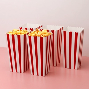 Classic red and white striped paper popcorn boxes with scalloped edges on pink background