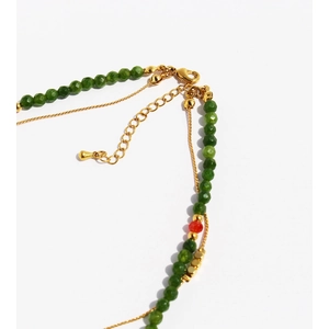 Double-layered beaded necklace with faceted green stones and gold chain detail