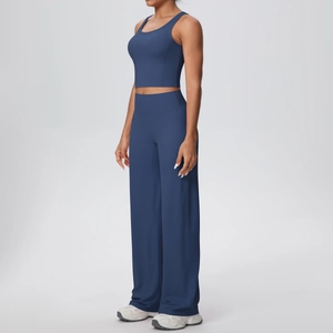 Dettaglio del set yoga blu scuro con canotta corta sportiva e pantaloni larghi dritti