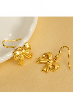 Detailed close-up of 18K gold plated titanium steel bow earrings with zircon stones