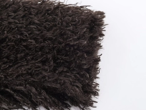 Macro shot of dark high-density faux fur texture with curly lamb wool effect details