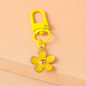 Close-up of a yellow cherry blossom keychain with gold hardware and intricate petals