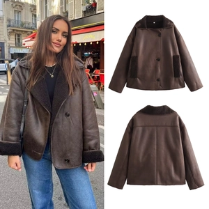Detail of dark brown faux shearling jacket featuring plush lapel and button closure