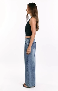 Detail shot of blue wide-leg jeans featuring a unique heart-shaped back pocket design