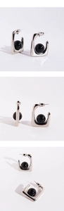 Detailed views of silver U-shaped earrings featuring black onyx beads in a minimalist style