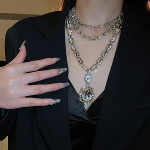 Macro detail of layered rhinestone necklace with large crystal teardrop pendant