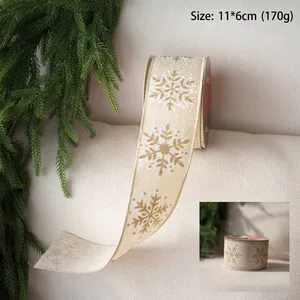 Detail of Christmas ribbon with gold and white snowflakes on cream velvet fabric