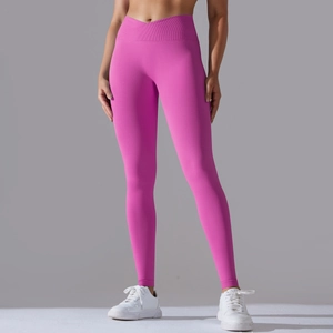 Detail view of pink high-waist yoga pants with cross-waist design and ribbed texture