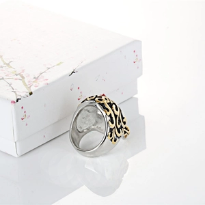 Detail view of a vintage silver skull ring with gold filigree and a red stone inlay