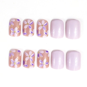 Short square press-on nails featuring purple floral patterns and solid lavender finish