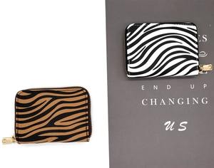 Detail of zebra pattern card holders with gold zippers in black and brown animal prints