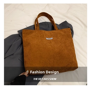 Detail of brown corduroy tote bag showing textured fabric and Fashion label