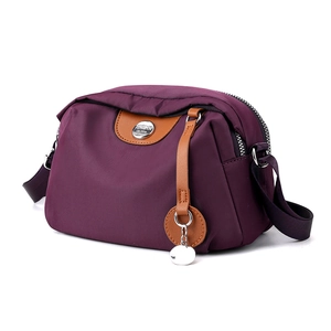 Borsa a tracolla in nylon viola con finiture marroni e tracolla regolabile su bianco