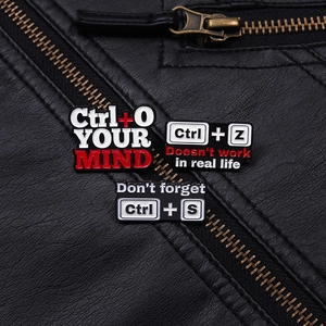 Three Ctrl+S keyboard shortcut enamel pins pinned on a black leather jacket